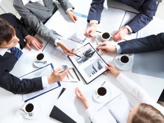 employees sitting at a table working on a project